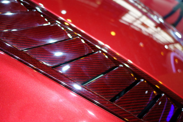 Cette année, la mode est au carbone coloré.  Le rouge sur l'Aston V12 Vantage S Roadster...